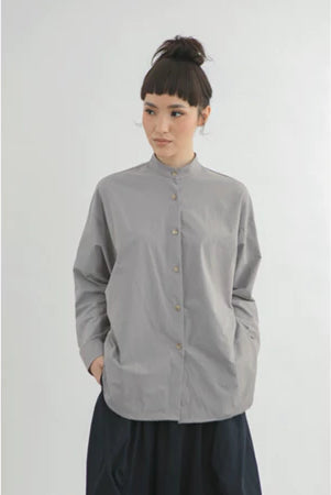 Person wearing a gray long-sleeve boxy shirt by Yestoday with a white background