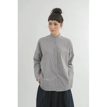 Person wearing a gray long-sleeve boxy shirt by Yestoday with a white background