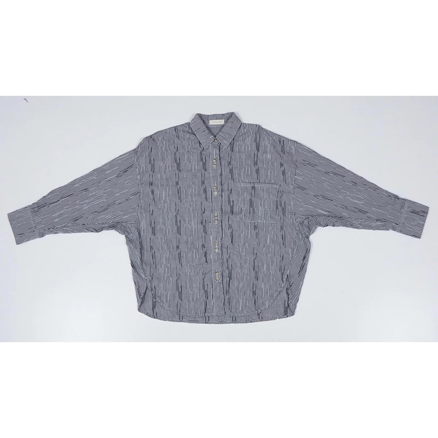 Black and white mini checkered oversized shirt by Yestoday with button details on a light gray background