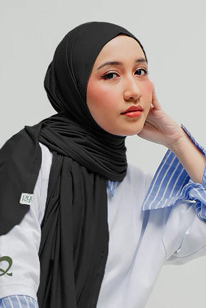 A woman wearing a black oval-edge pashmina scarf, paired with a lace-trimmed top.