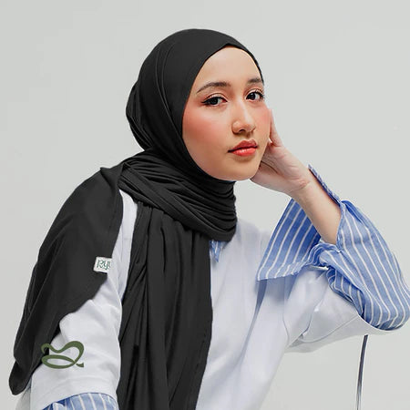 A woman wearing a black oval-edge pashmina scarf, paired with a lace-trimmed top.