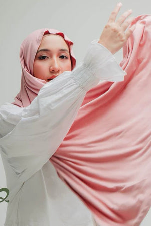 A woman wearing a pink-colored oval-edge pashmina scarf.
