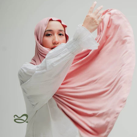 A woman wearing a pink-colored oval-edge pashmina scarf.