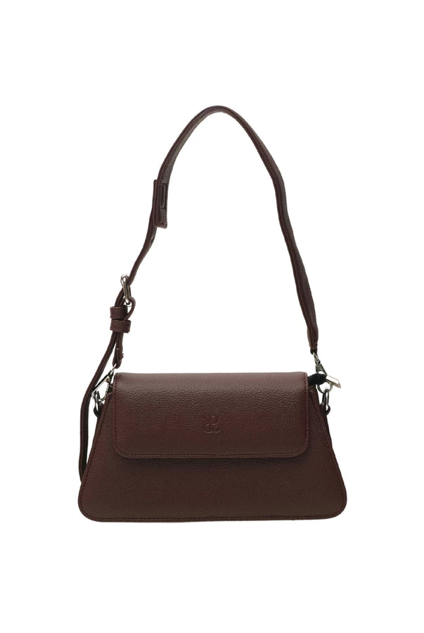 Burgundy-colored leather woman's handbag by Prior with a strap on a white background.
Tas tangan wanita berwarna burgundy dari kulit oleh Prior dengan tali pada latar belakang putih.