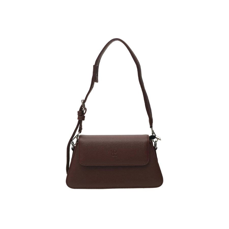 Burgundy-colored leather woman's handbag by Prior with a strap on a white background.
Tas tangan wanita berwarna burgundy dari kulit oleh Prior dengan tali pada latar belakang putih.