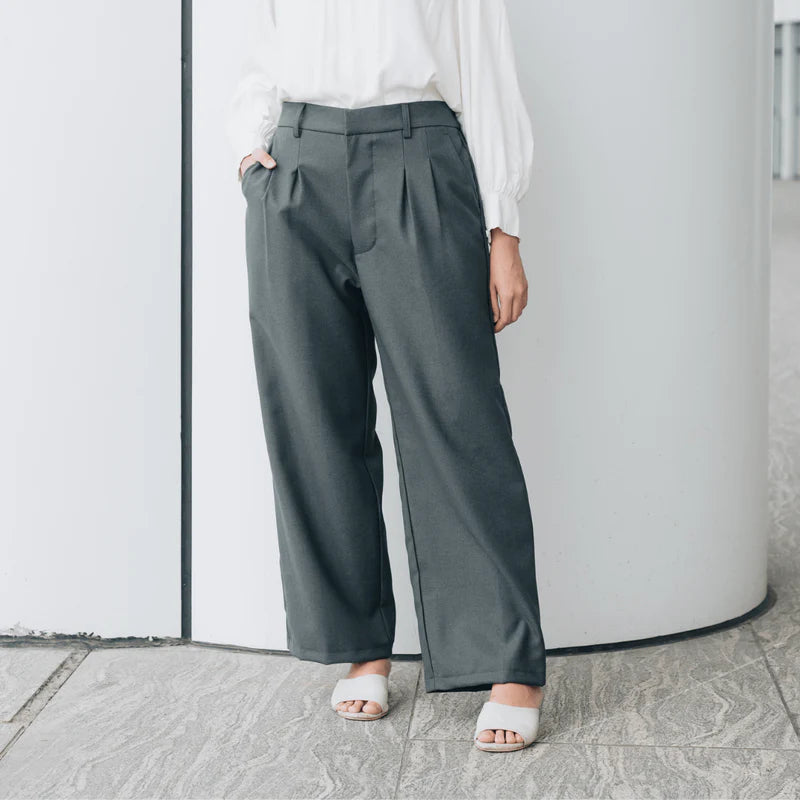 Person wearing dark gray wide-leg pants from Atala Scarves and white sandals against a light background