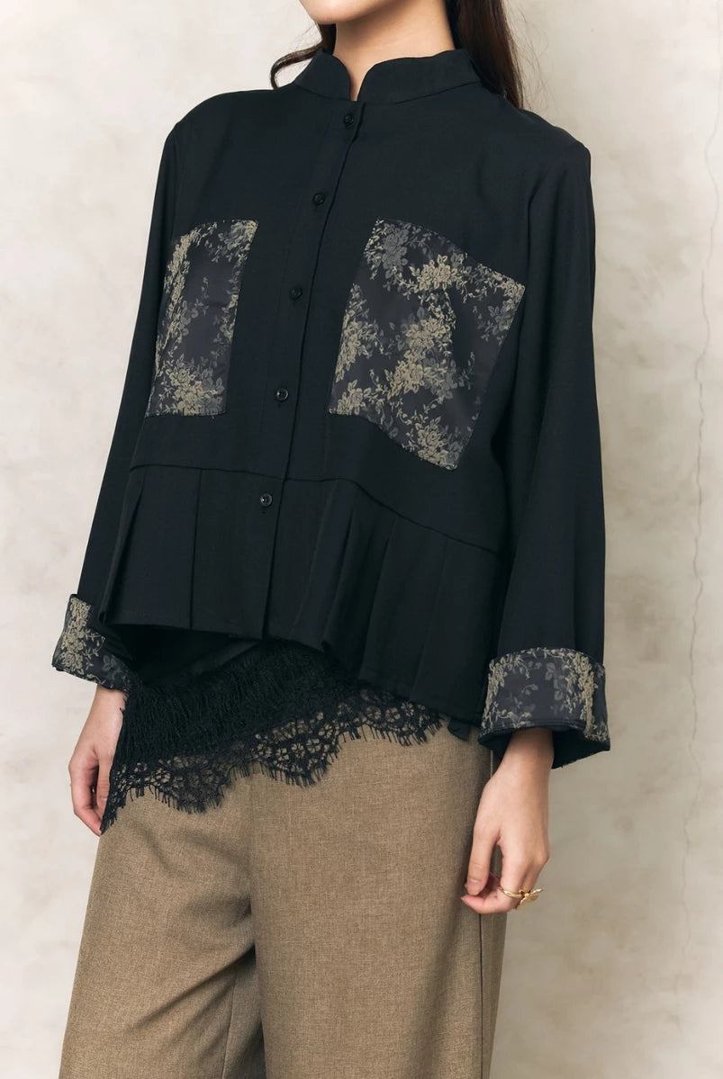 Black shirt by Studio Tui with lace details worn by a person against a neutral background