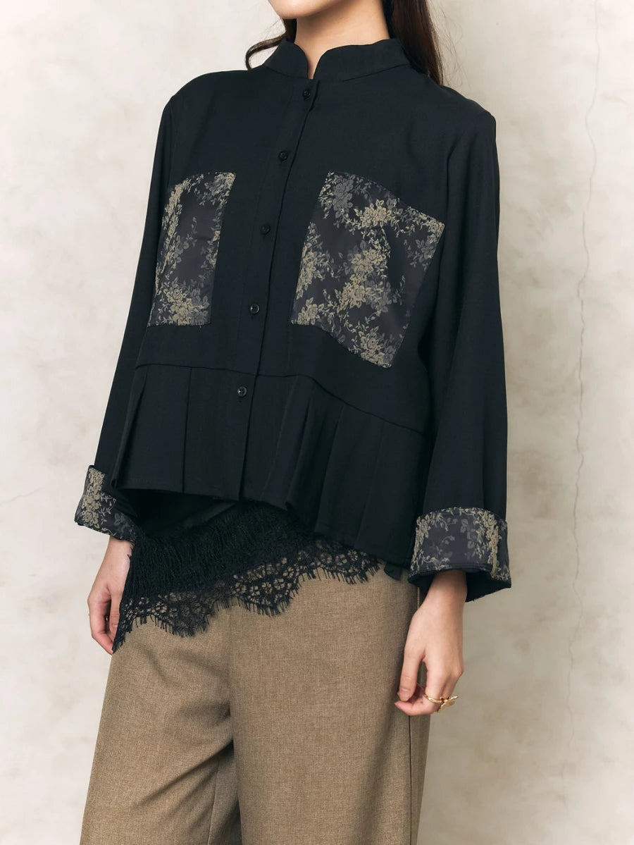 Black shirt by Studio Tui with lace details worn by a person against a neutral background