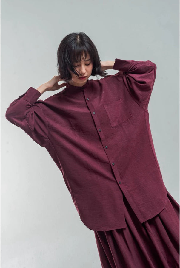 Woman wearing a burgundy oversized shirt by Yestoday against a plain background