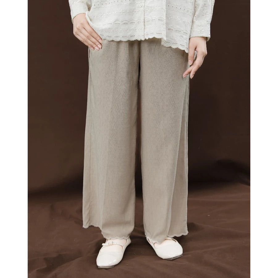 Person wearing taupe-colored wide-leg culottes by Mistyvori and a light-colored top on a brown background
Seorang wanita mengenakan celana culotte lebar berwarna taupe dari Mistyvori dan atasan berwarna terang dengan latar belakang cokelat