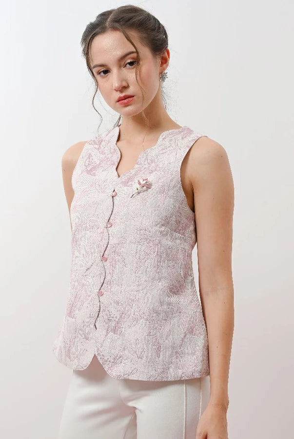 Woman wearing a light pink floral sleeveless vest by Holy Peony against a white background