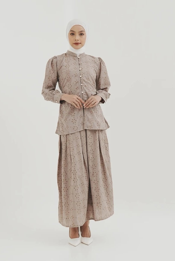 Woman wearing a patterned latte-colored skirt by Tunique on a white background