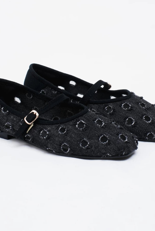 A pair of black flatshoes with a textured, woven circular pattern and a small gold buckle on the strap by Cekhas, shown on a white background.