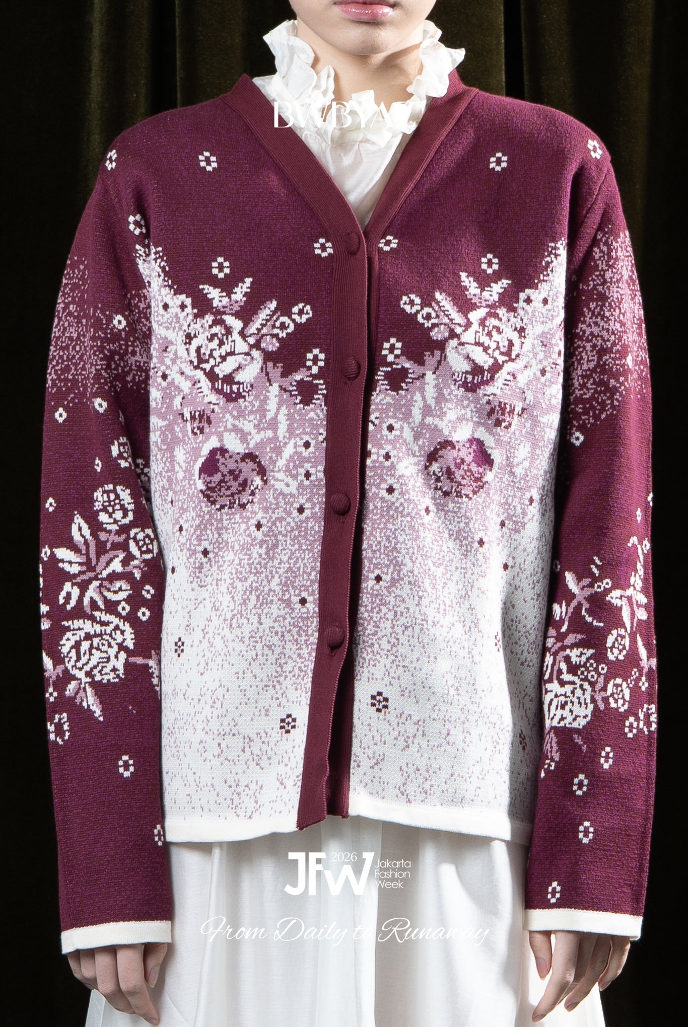 Person wearing a maroon cardigan with floral patterns by BWBYAZ on a dark background