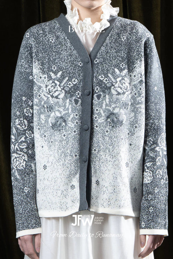 Person wearing a grey patterned cardigan by BWBYAZ over a white shirt with a dark background