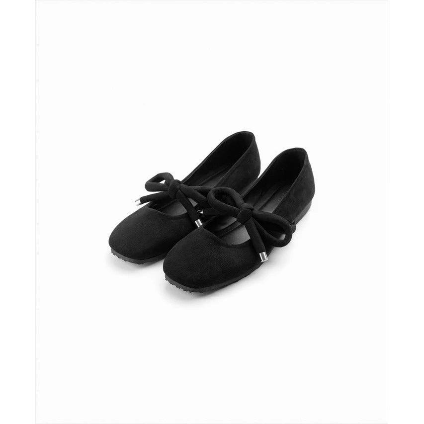 Pair of black flat shoes with a bow by Cajsa on a white background