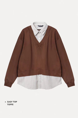 Brown sweater with white shirt underneath on a light gray background