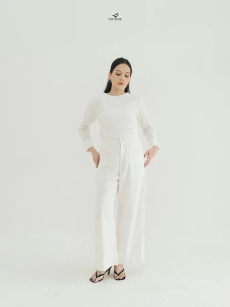 Person wearing a white top and wide-leg pants by Swifter with a brand logo on a white background