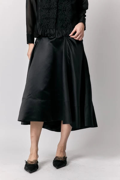 Person wearing a black outfit with a skirt by Studio Tui on a plain background