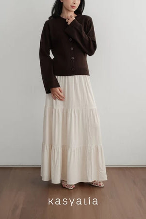 Person wearing a brown top and white skirt with 'kasyalia' branding.