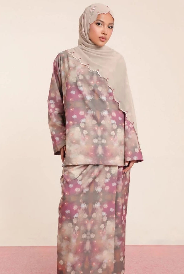Woman wearing a floral rose patterned tunic set by Lozy Hijab with a hijab on a beige background.
Seorang wanita mengenakan set tunik bermotif bunga mawar dari Lozy Hijab dengan hijab di atas latar belakang berwarna krem.