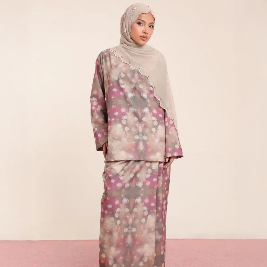 Woman wearing a floral rose patterned tunic set by Lozy Hijab with a hijab on a beige background.
Seorang wanita mengenakan set tunik bermotif bunga mawar dari Lozy Hijab dengan hijab di atas latar belakang berwarna krem.