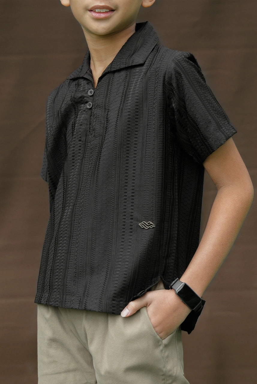 Child wearing a black patterned shirt by Mistyvori and beige pants against a brown background