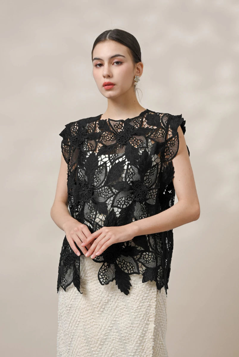 Woman wearing a black lace vest by Kasa Heritage against a beige background