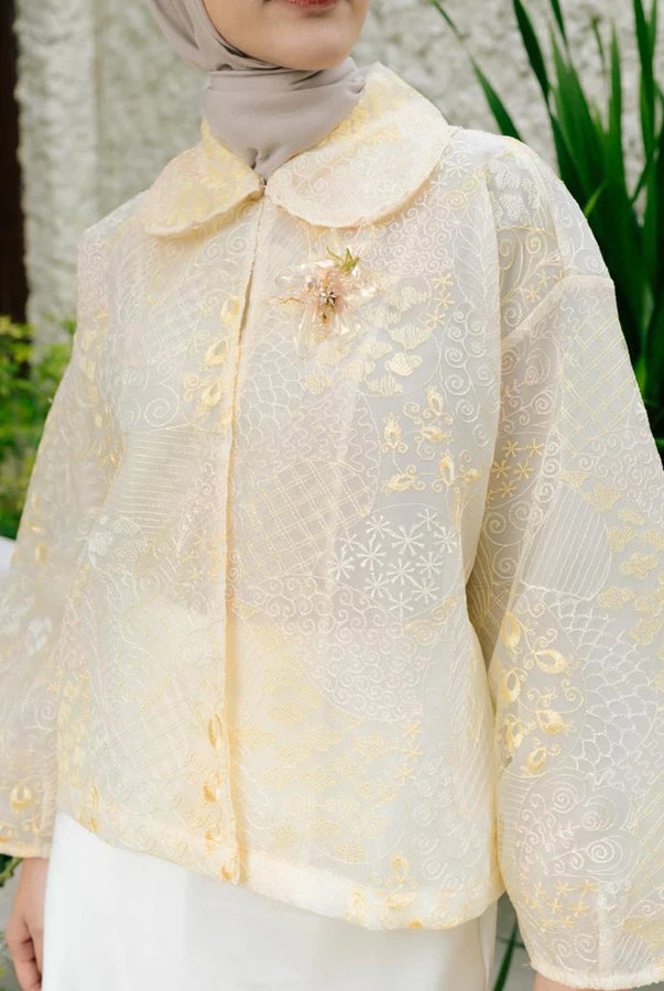 Woman wearing a yellow lace outer with floral details by Haidee Orlin in an outdoor setting.