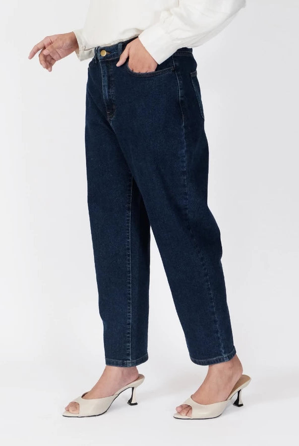 A model wearing dark wash blue denim pants, a white long-sleeve blouse, and white slingback kitten heels, shown from the waist down against a plain white studio background.
Seorang model mengenakan celana denim biru dengan warna gelap, blus lengan panjang berwarna putih, dan sepatu kitten heels slingback putih, difoto dari pinggang ke bawah dengan latar belakang studio berwarna putih polos.