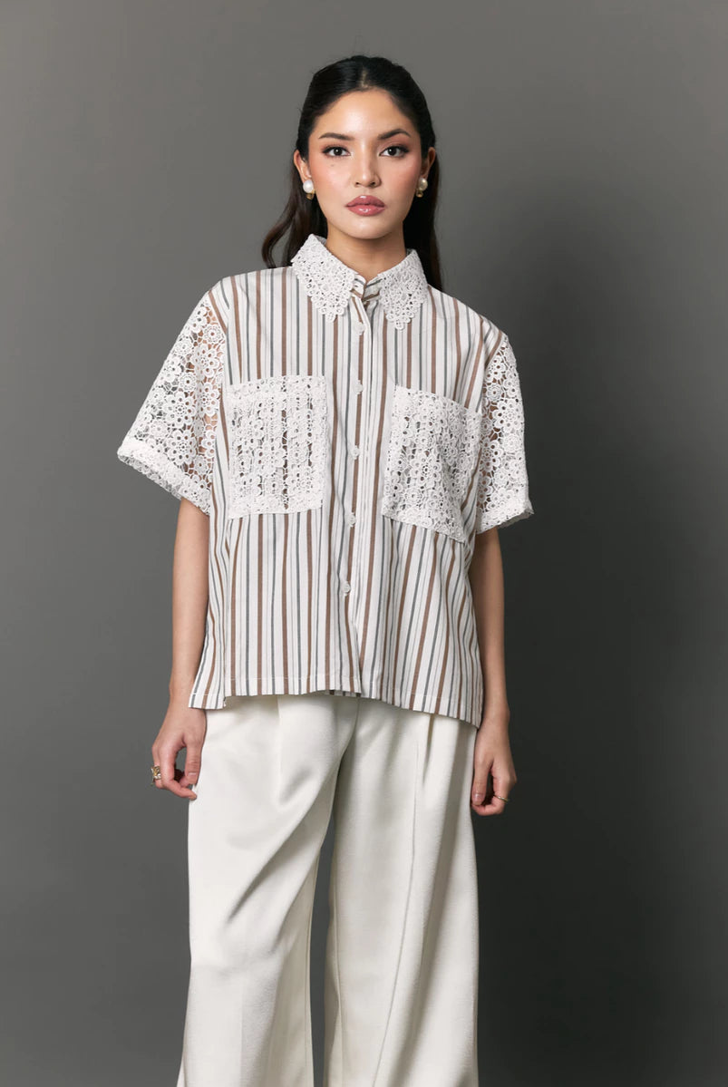 Woman wearing a striped shirt with lace details by Studio Tui against a gray background