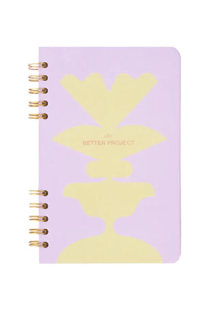 Purple notebook with yellow abstract design from Muhajir Project on a white background