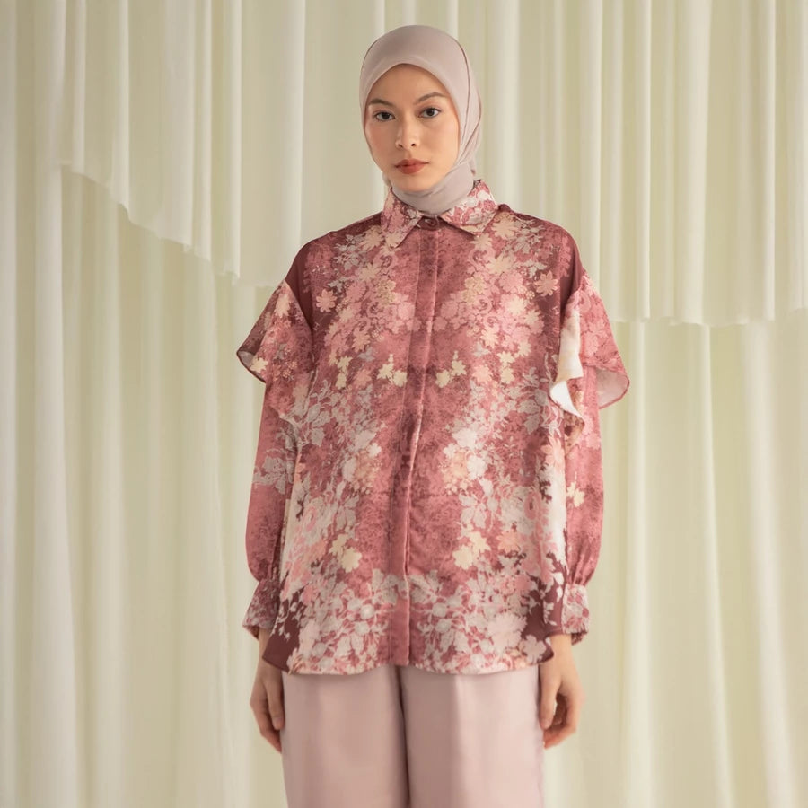 Woman wearing a rosewood-colored floral shirt by Hijabchic and hijab against a light background