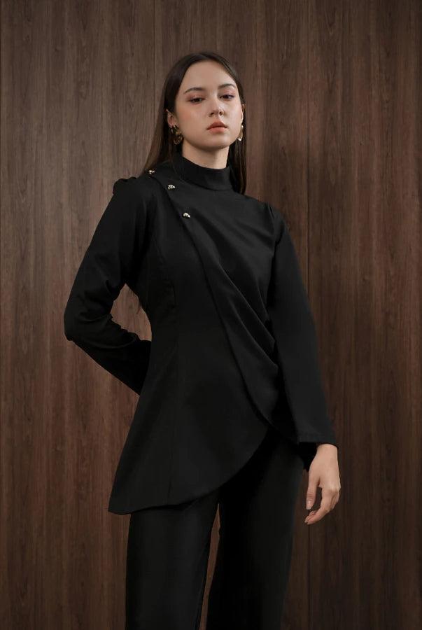 Woman wearing a black blouse by Kasa Heritage against a wooden background