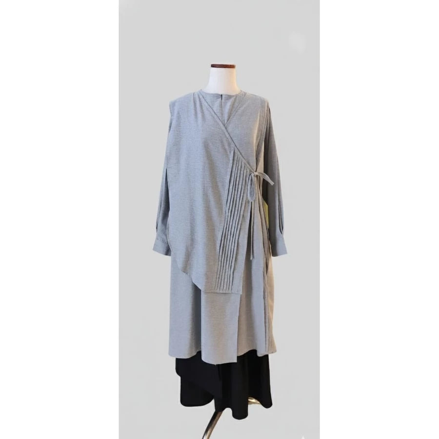 A Misty grey tunic by Legan on a mannequin against a white background.
Sebuah tunik abu-abu misty dari Legan di manekin dengan latar belakang putih.