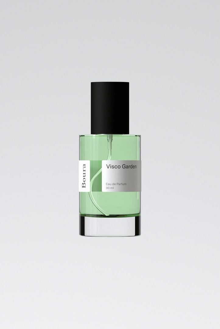 A bottle of 'Visco Garden - Boura' perfume with a clear green liquid visible inside, a black cap, and a white label.