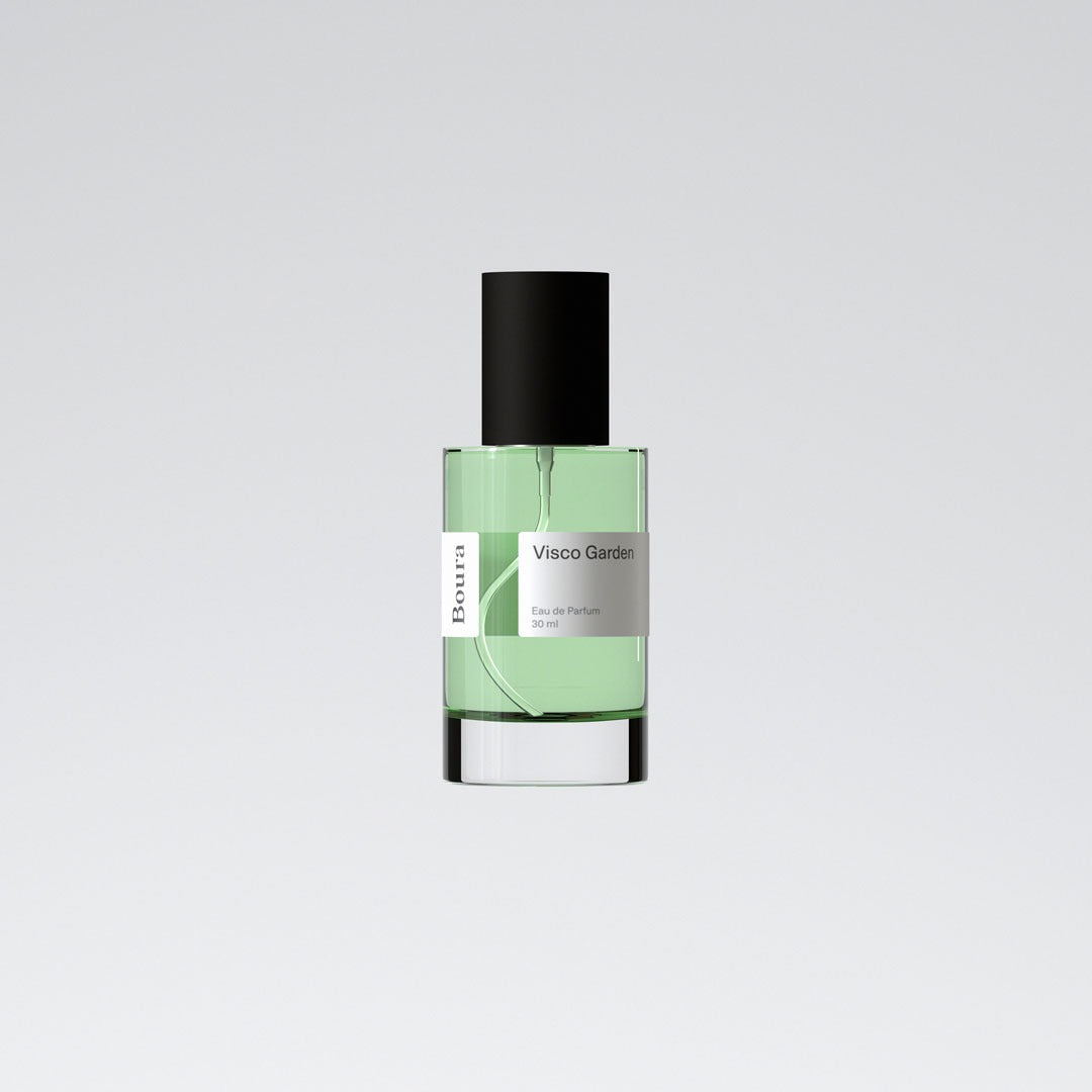 A bottle of 'Visco Garden - Boura' perfume with a clear green liquid visible inside, a black cap, and a white label.