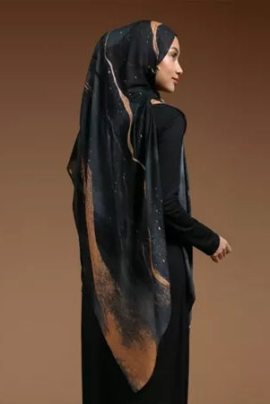 Woman wearing a black hijab with gold accents by Lozy Hijab on a brown background