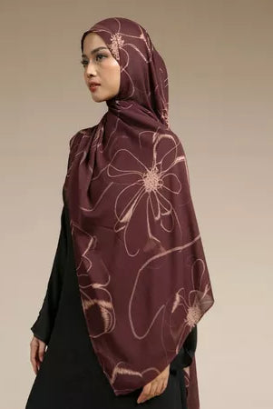 Woman wearing a maroon hijab with floral patterns by Lozy Hijab on a beige background