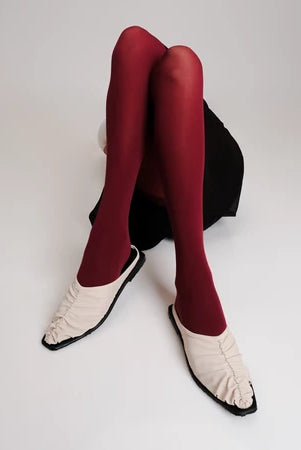 Red tights and ivory Vonee Mules flat shoes by Cekhas on a white background