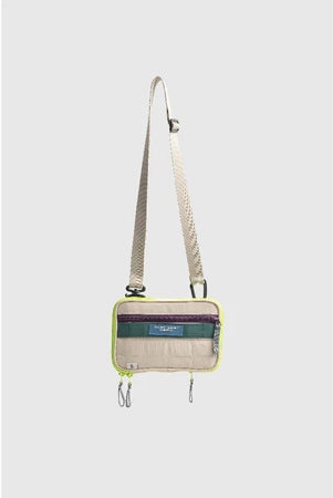 Small neon crossbody bag with a strap from Muhajir Project on a light gray background