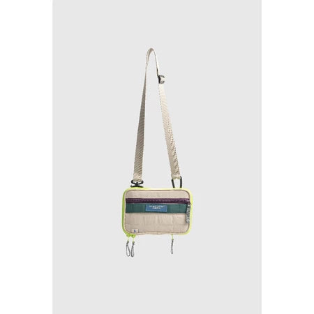 Small neon crossbody bag with a strap from Muhajir Project on a light gray background
