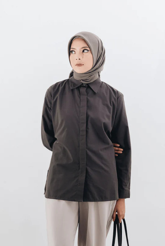 Woman wearing a dark brown shirts from Atala Scarves and beige hijab against a white background