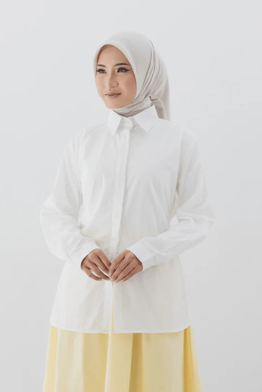 Person wearing a white shirt from Atala Scarves with a yellow skirt on a plain background