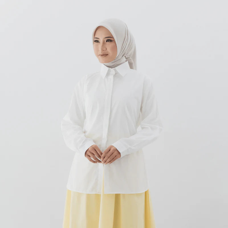 Person wearing a white shirt from Atala Scarves with a yellow skirt on a plain background