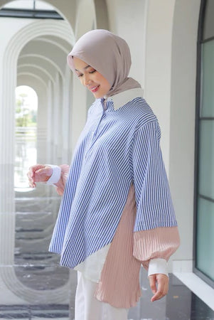 Woman wearing a blue and white striped shirt by Casa Elana with a hijab in an outdoor setting