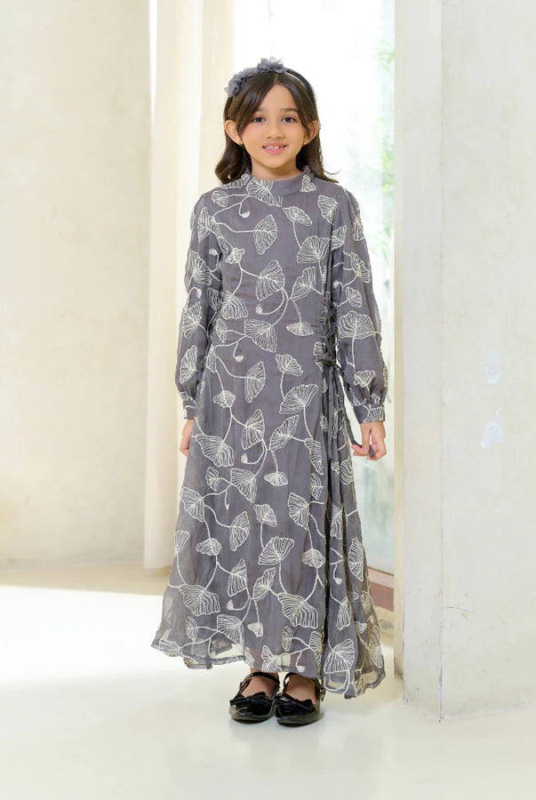 Young girl wearing a long floral grey dress by Kasa Heritage in a minimalistic setting