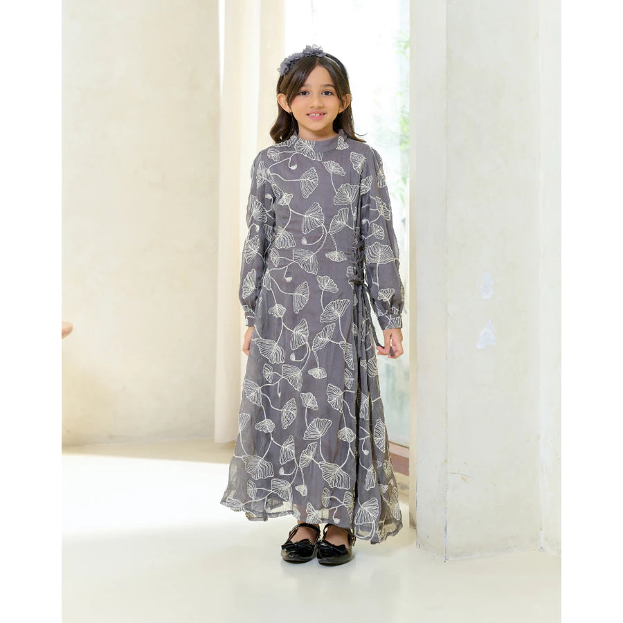 Young girl wearing a long floral grey dress by Kasa Heritage in a minimalistic setting