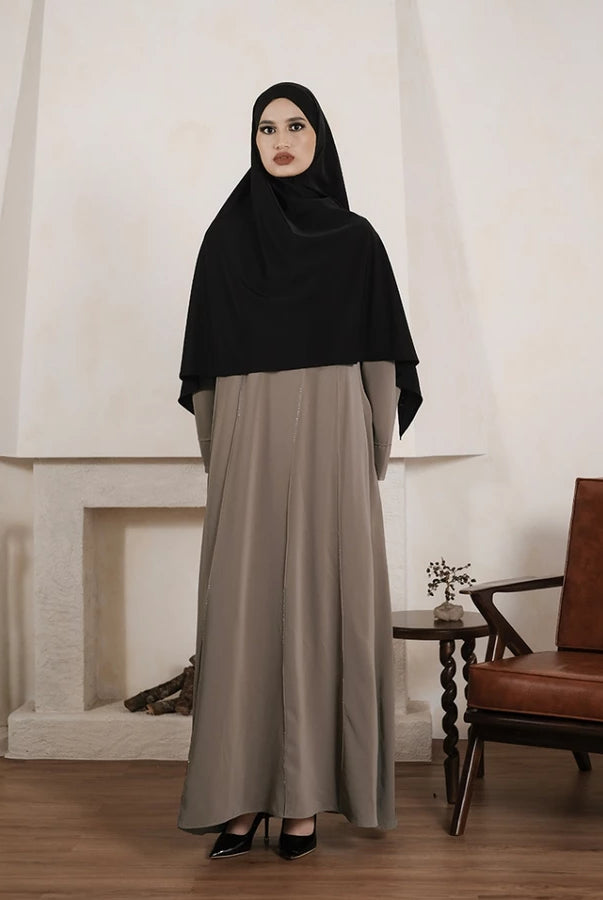 Person wearing a brown abaya by Tubita on a white background