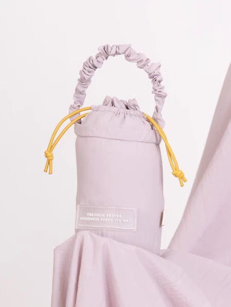 Light purple drawstring bag from Muhajir Project with a label on a white background